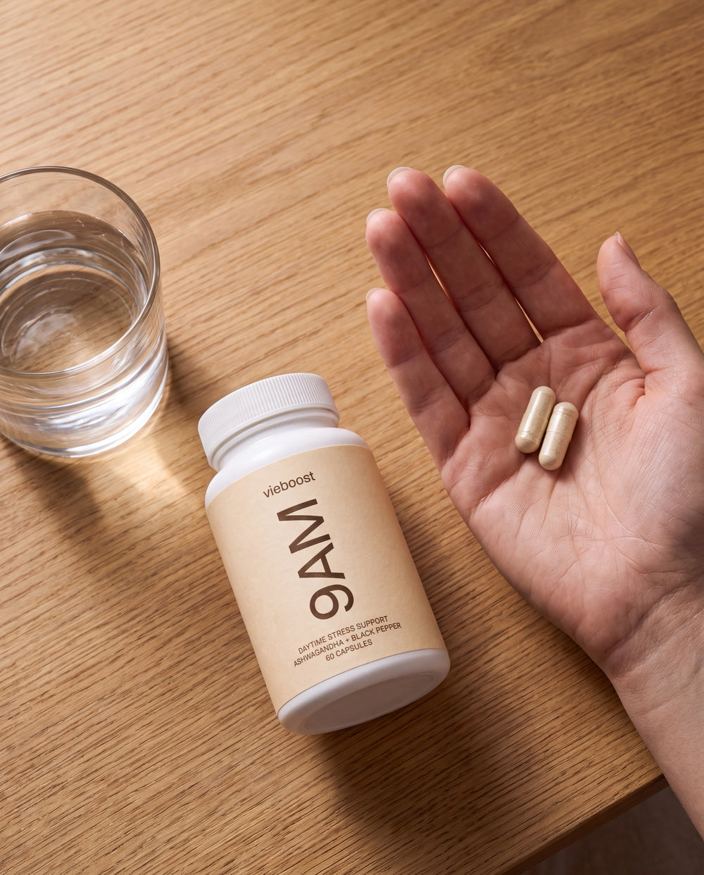 Two 9AM capsules in hand - one with breakfast, one midday